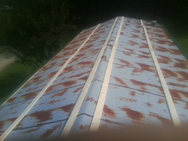 Rusted metal roof panels with new wood purlins before replacement — Storm Damage Roof Repair in Bryn Athyn by Roofing Brothers